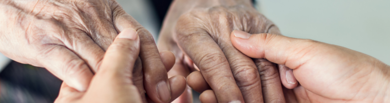 Auf dem Foto sind zwei Paar Hände zu sehen, die sich halten.